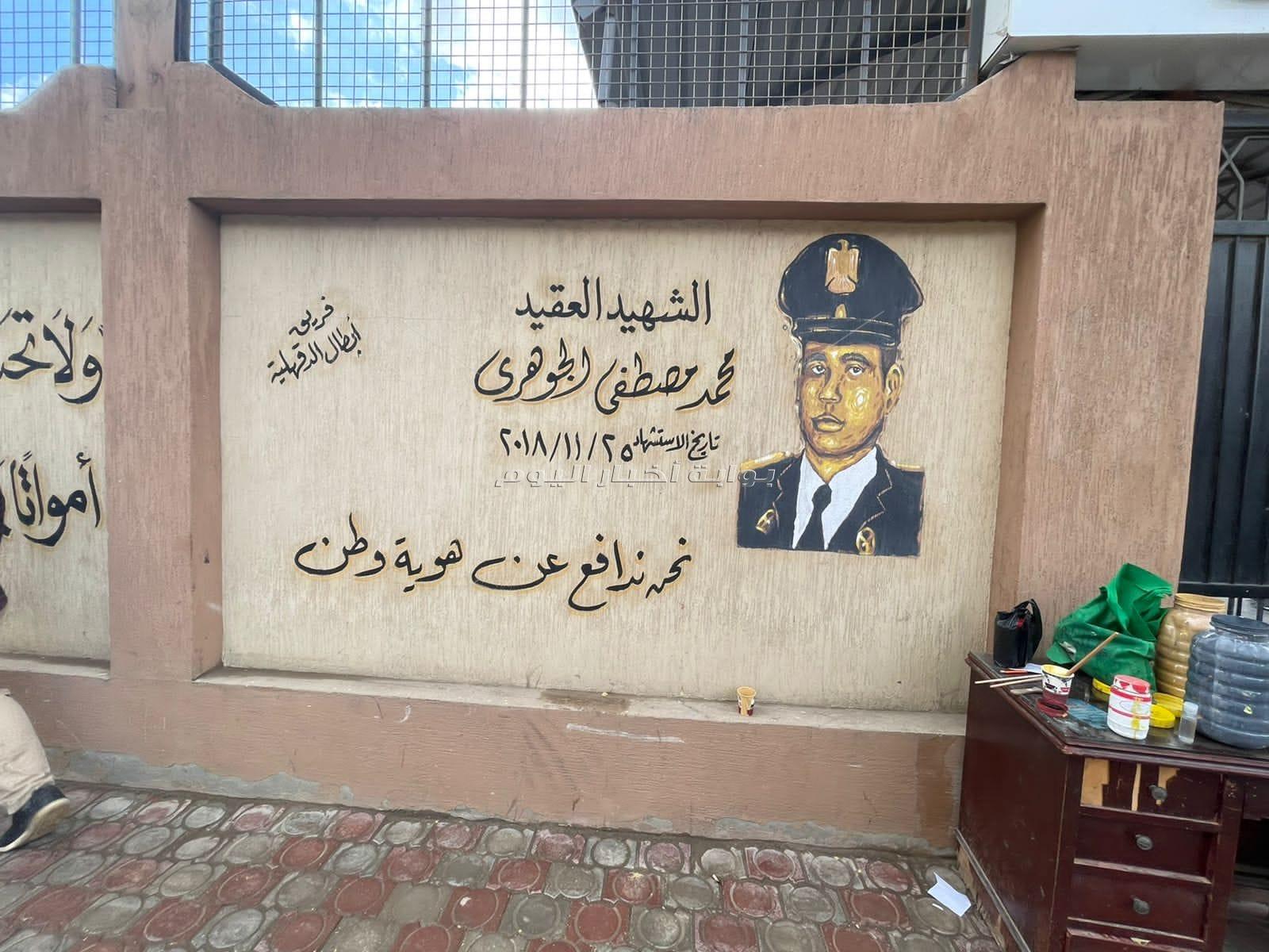 فريق طلاب الجامعات يزينون جدران المدارس والمنشآت بالدقهلية بصور شهداء الجيش والشرطة