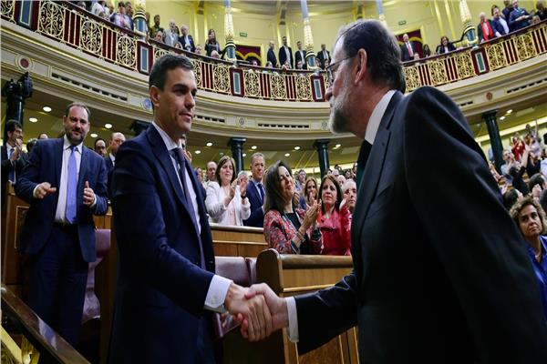 رئيس الوزراء الجديد بيدرو سانتشيث يصافح رئيس الحكومة السابق ماريانو راخوي