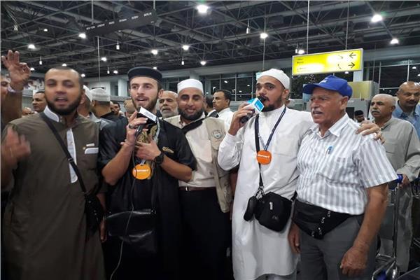 الحجاج ينشدون الأغني الدينية بمطار القاهرة