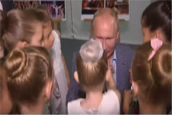 الرئيس الروسى بوتين يجلس على ركبتيه ليقبل يد طفلة صغيرة
