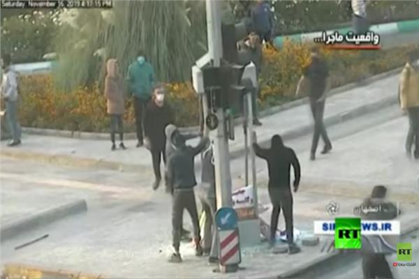 شباب إيراني يقوم بتدمير إشارات المرور