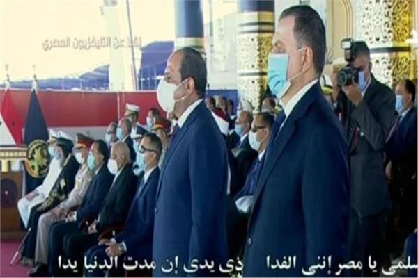 | الرئيس السيسي ووزير الداخلية يقفان أثناء تحية العلم المصري