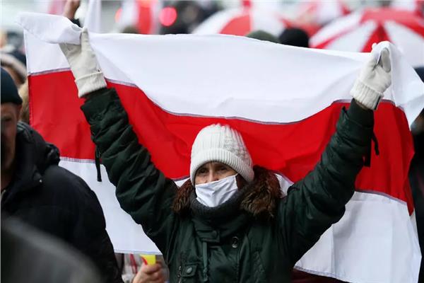 امراة تحمل علم المعارضة البيلاروسية في مينسك (ا ف ب)