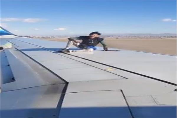 أمريكي يصعد على جناح طائرة