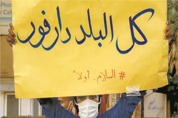 متظاهر فى الخرطوم يرفع لافتة تضامن مع إقليم دارفور 