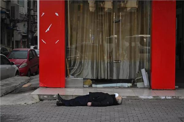رجل ميت مستلق على رصيف في مدينة ووهان الصينية ف