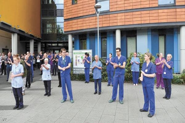  أطباء وممرضون خارج أحد المستشفيات البريطانية  