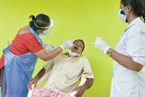  عاملة صحة تسحب عينة اختبار كورونا فى الهند   