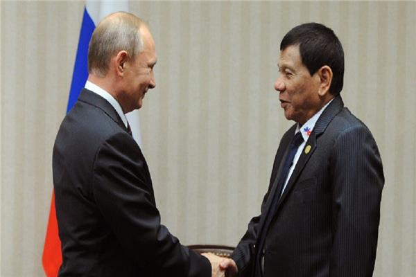 الرئيس الفلبيني رودريجو دوتيرتي يصافح الرئيس الروسي بوتين في لقاء سابق