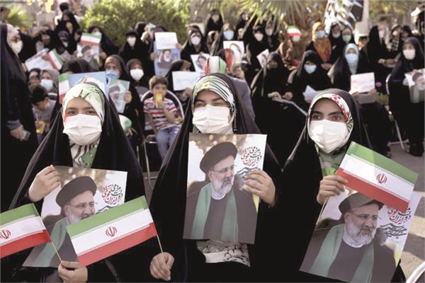 إيرانيات يحملن صورة رئيسي فى أحد شوارع طهران خلال الحملة الانتخابية    