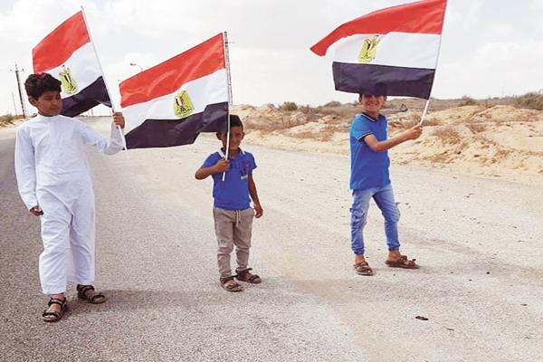  أطفال القرية يرفعون العلم المصرى تعبيراً عن الفرحة