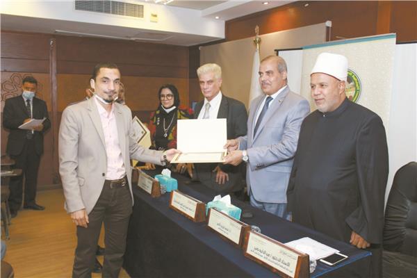 رئيس جامعة الأزهر يسلم أحد الفائزين شهادة التكريم