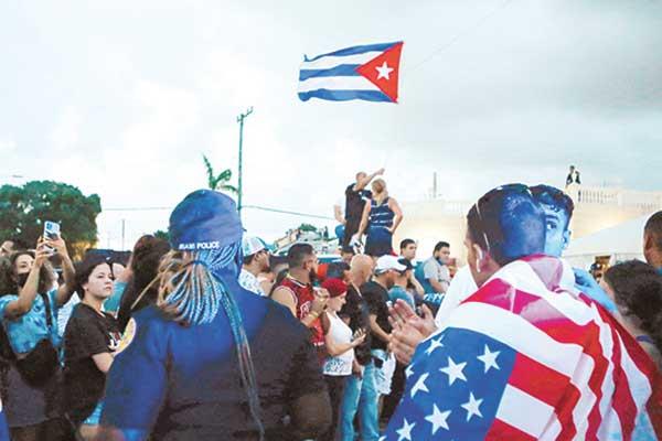متظاهرون فى كوبا يحملون أعلام بلادهم والعلم الأمريكي ( ا ف ب)
