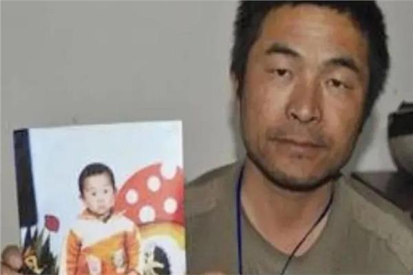 غوو جانغتانج حاملا صورة ابنه 