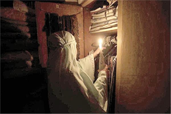 سيدة لبنانية تستخدم الشموع لتدبير أمورها المنزلية. «صورة من أ ف ب»