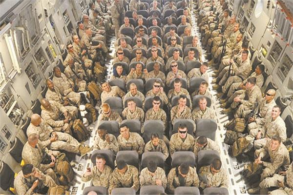 جنود أمريكيون فى طائرة تجليهم من أفغانستان وقد بدت السعاة على وجوه بعضهم   