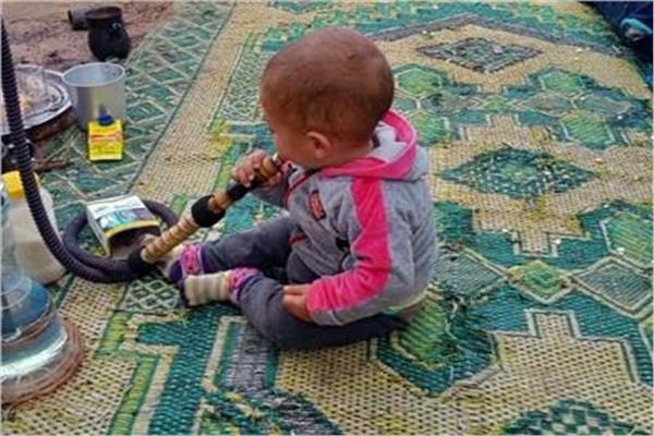 الطفل معتز محمد سعيد وهو يدخن «الشيشية»