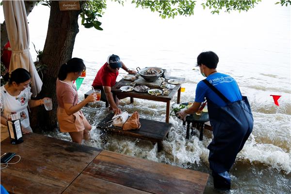 شعب تايلاند يستمتع بتناول الطعام في الماء بعد إعصار ديانمو