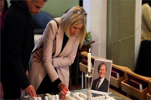 اسرة ديفيد أميس تضئ الشموع اثناء جنازته