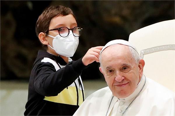 الطفل الصغير يشير الي قباعة البابا 