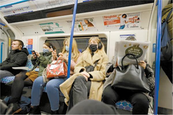 بريطانيون يرتدون كمامات فى مترو الأنفاق للحد من انتشار كورونا.