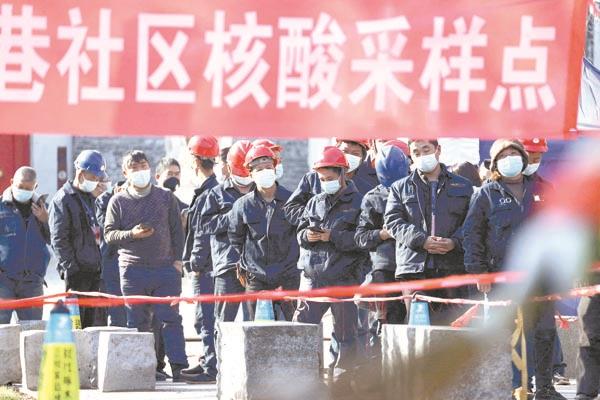 عمال البناء فى مدينة شيان الصينية يصطفون لإجراء تحاليل كورونا