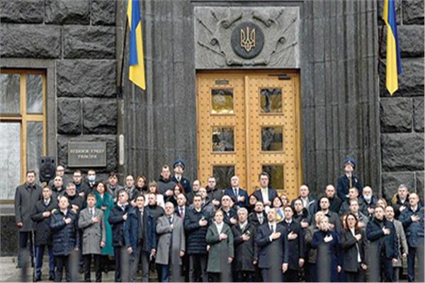 رئيس وأعضاء الحكومة الأوكرانية يؤدون النشيد الوطنى أمام مقر رئاسة الوزراء أمس بمناسبة