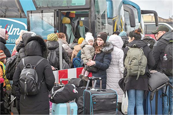 لاجئون يستعدون لركوب حافلة تنقلهم على الحدود مع بولندا إلى ألمانيا