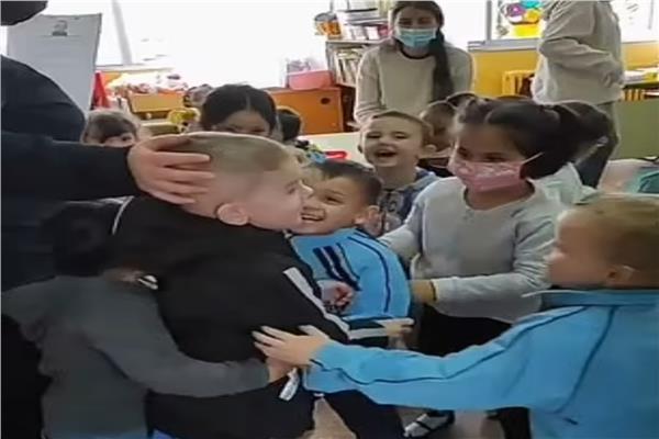 طفل أوكراني يحتضنه زملاؤه الجدد 