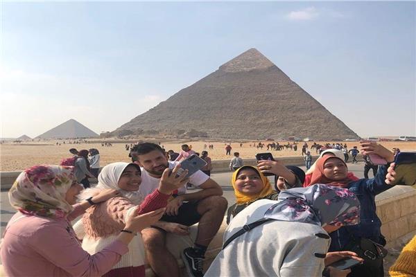سياح يلتقطون صور مع الاطفال المصريين في المناطق الاثرية