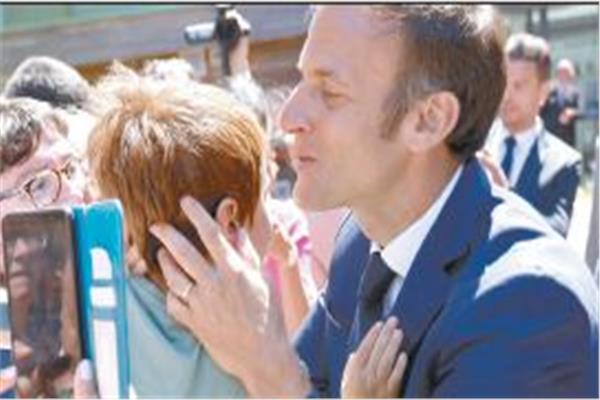 ماكرون يقبل طفلاً بعد التصويت بأحد مراكز الاقتراع 