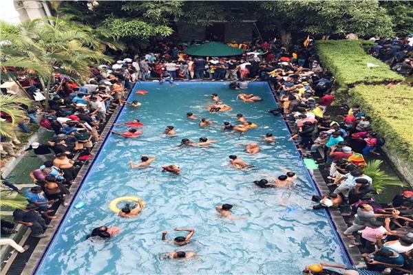 متظاهرو سريلانكا يسبحون في حمام سباحة الرئيس بعد فراره 