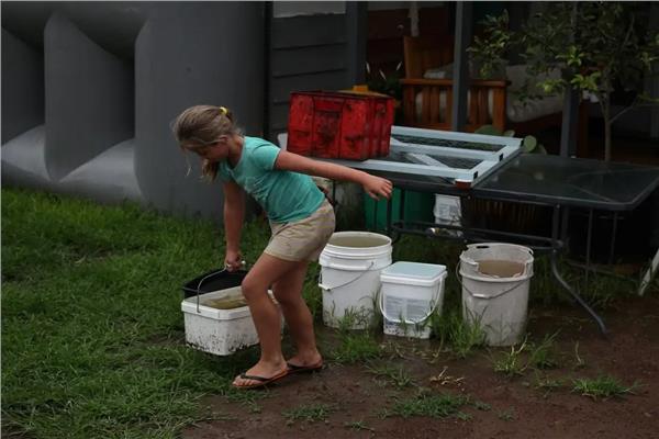 فتاة تحمل مياه الأمطار للشرب
