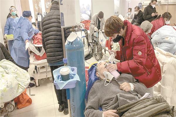 امرأة تساعد مريضًا في مستشفى بشنغهاي