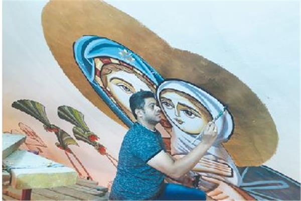 الفنان أرميا القشطة أثناء رسمه لأكبر جدارية فى كاتدرائية العاصمة الإدارية الجديدة