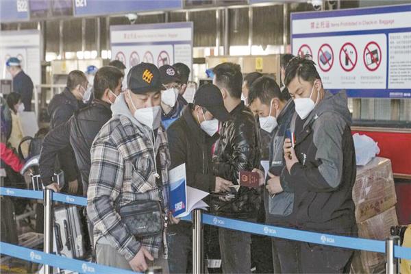 مسافرون أمام مكتب تسجيل الوصول فى مطار  بكين الدولى 