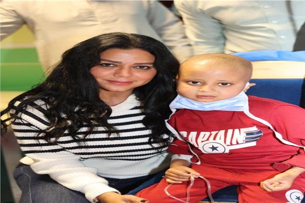 رانيا يوسف برفقة أحد الأطفال المرضى