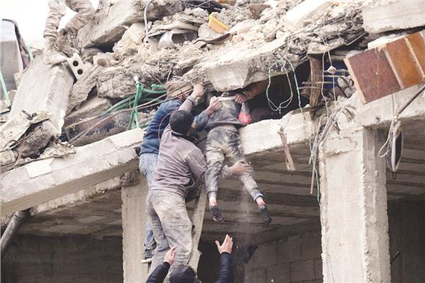 محاولة إنقاذ طفلة من تحت أنقاض مبنى منهار إثر الزلزال فى ريف حلب