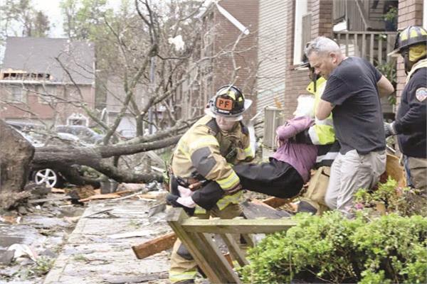 رجال الإطفاء ينقلون امرأة مسنة من منزلها بعد الإعصار 