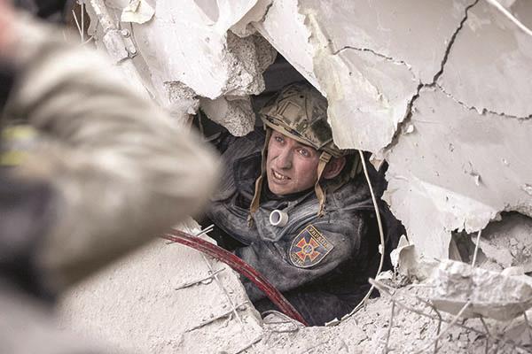 رجل إنقاذ يبحث عن ناجين تحت أنقاض المبنى المنهار   «صورة من أ ف ب»