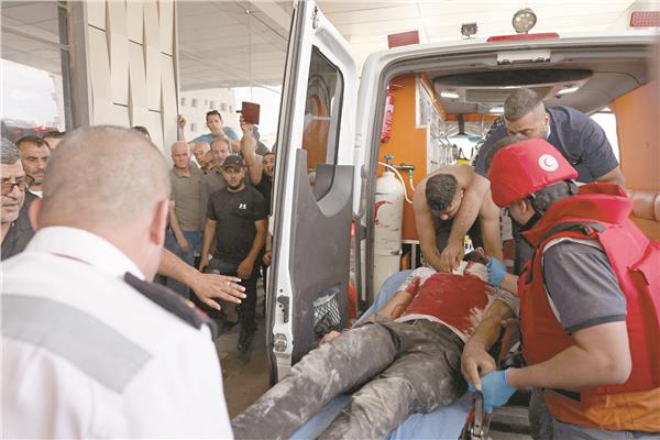 مسعفون ينقلون فلسطينيا إلى المستشفى بعد إصابته فى جنين