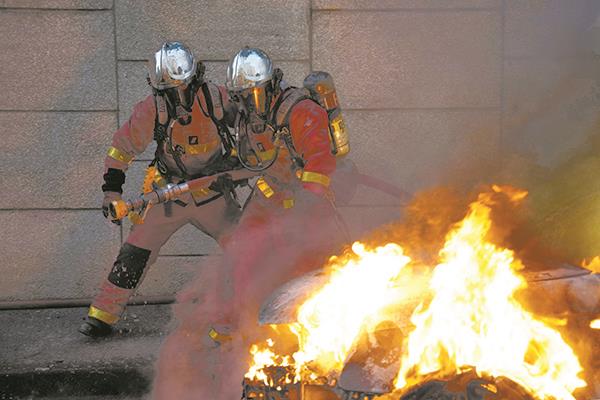 رجال إطفاء يحاولون إخماد حريق سيارة أشعلها محتجون غربى باريس