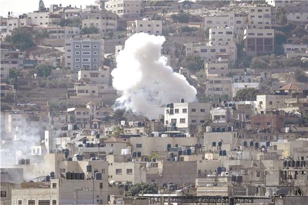 الدخان يتصاعد من أحد مبانى مخيم جنين جراء قصف إسرائيلى جوى