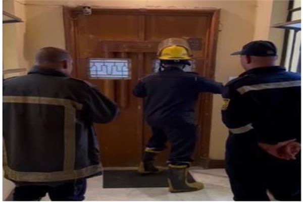 رجال الحماية المدنية خلال فتح باب شقة السيدة