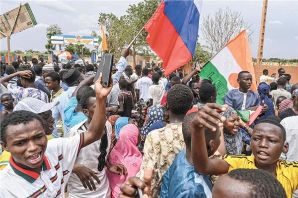 متظاهرون يرفعون اعلام النيجر وروسيا أمام القاعدة العسكرية الفرنسية فى نيامى