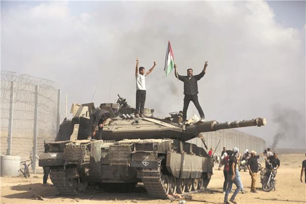 فلسطينيون يرفعون العلم على دبابة إسرائيلية