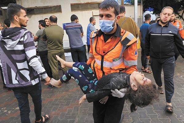 مسعف فلسطينى يحمل جثمان طفلة استشهدت فى غارة إسرائيلية 