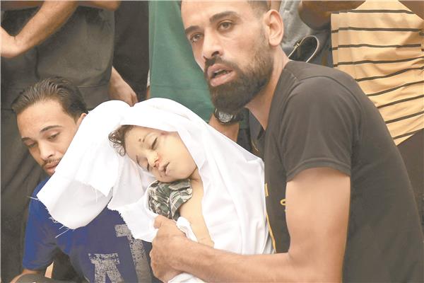 فلسطينى يودع طفله بعد استشهاده فى غارة إسرائيلية جنوب قطاع غزة