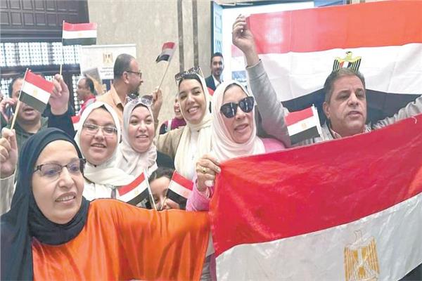 مواطنون مصريون يرفعون الأعلام المصرية خلال الإدلاء بأصواتهم