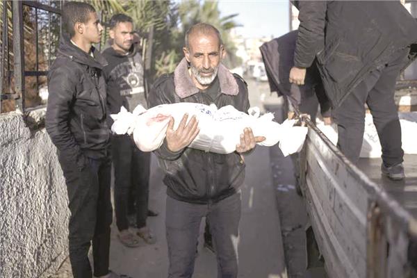 فلسطينى يحمل جثمان حفيده